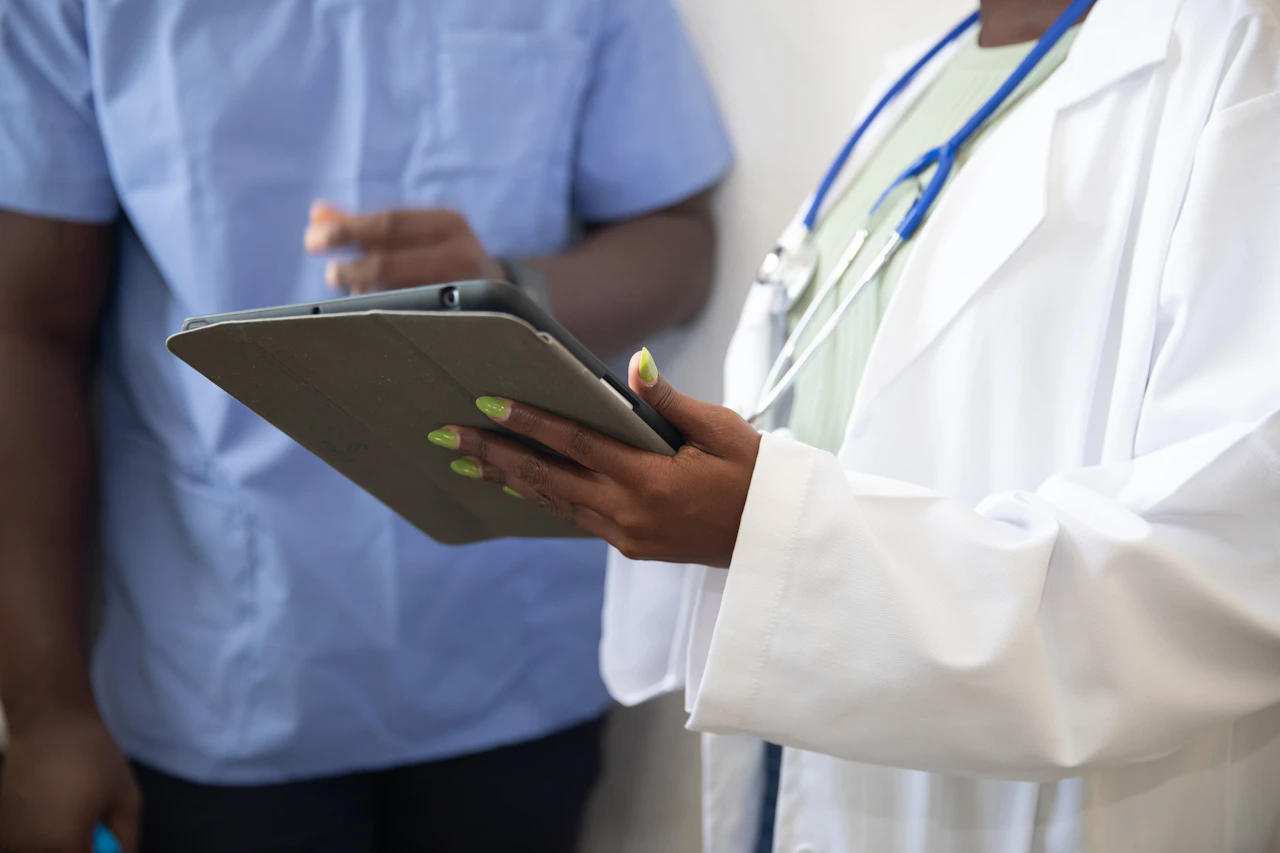Two clinicians reviewing notes on a tablet